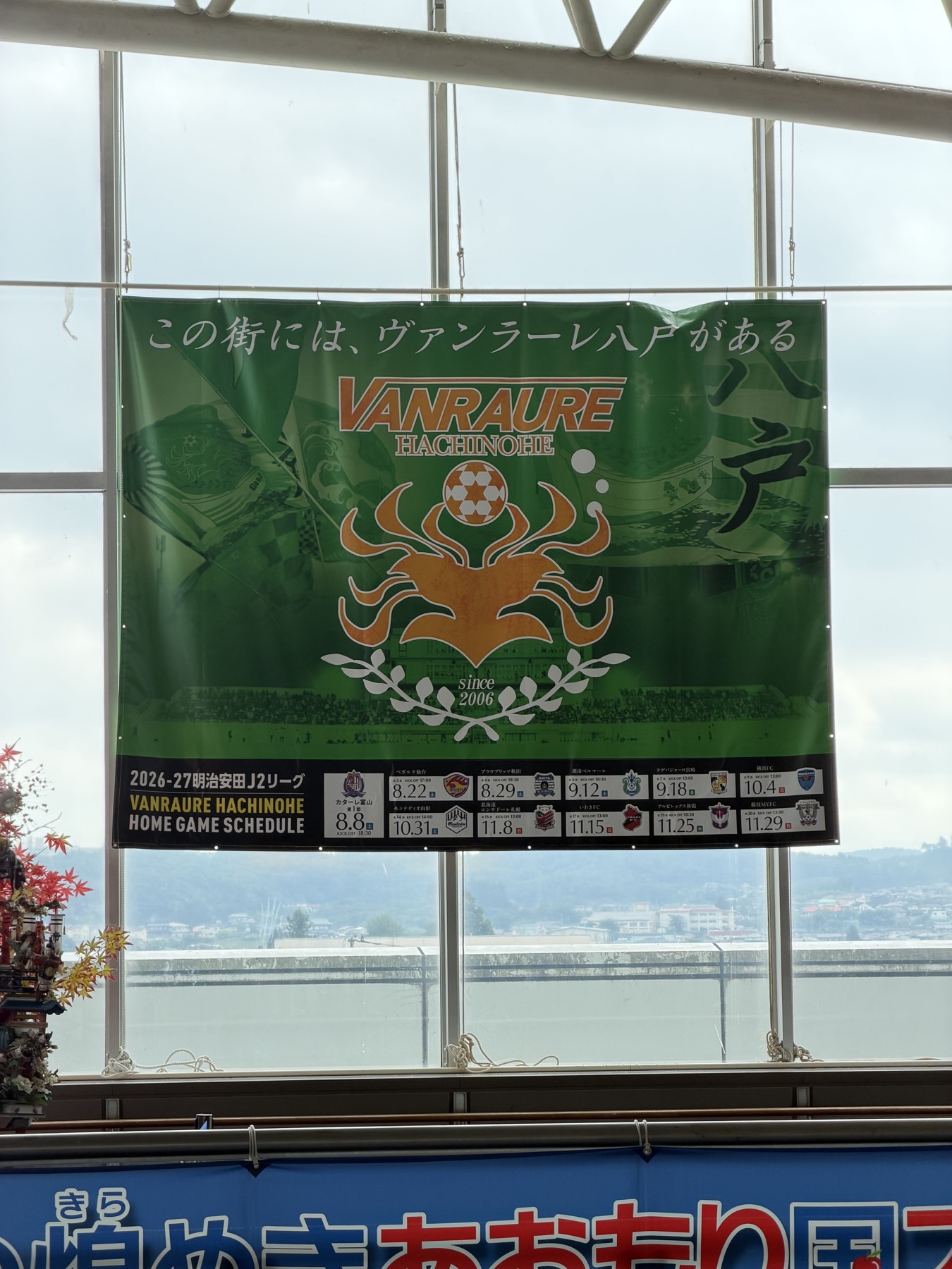八戸駅に掲示されたヴァンラーレ八戸のエンブレムとホームゲーム日程